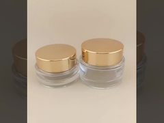Vaso di crema di vetro trasparente con coperchio a vite dorata per lozione femminile