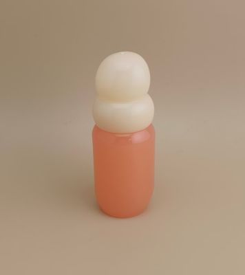 Bottiglia di vetro rosa con tappo bianco panna per profumo da ragazza